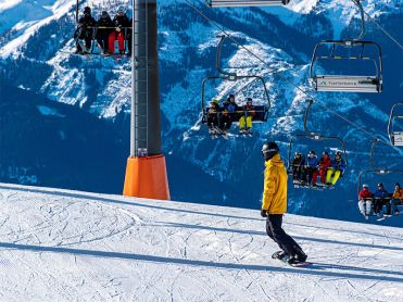 Snowboarder below chair lift